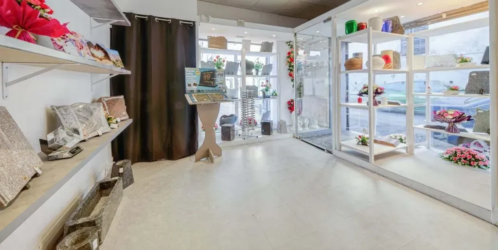 Intérieur de la boutique avec plaques en granit, urnes et présentoir d'articles funéraires
