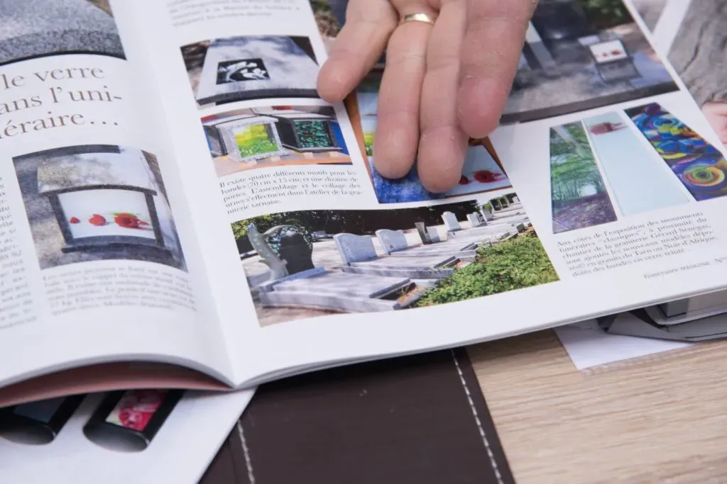 Consultation d'un catalogue illustré de monuments funéraires et d'articles de marbrerie